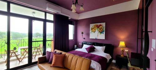 にある寄寓 Ji-Yuの紫の壁のベッドルーム、ベッド、バルコニーが備わります。