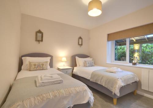 a bedroom with two beds and a window at Little Orchard in Sedlescombe