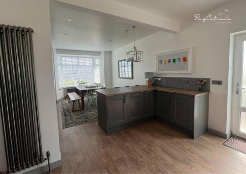 cocina con encimera y mesa en una habitación en Stylish Brixham home, sleeps 7, parking & garden, en Brixham
