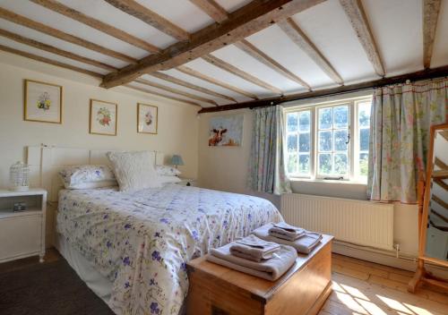a bedroom with a bed with towels on a table at Marigold Cottage in Rolvenden