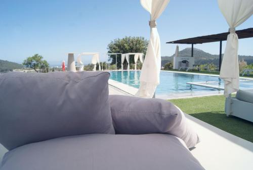 un sofá blanco sentado junto a una piscina en Agroturismo Ses Cases de Fetget, en Son Servera