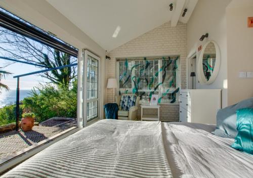 a bedroom with a bed and a large window at Melbury Abbas in Sandgate