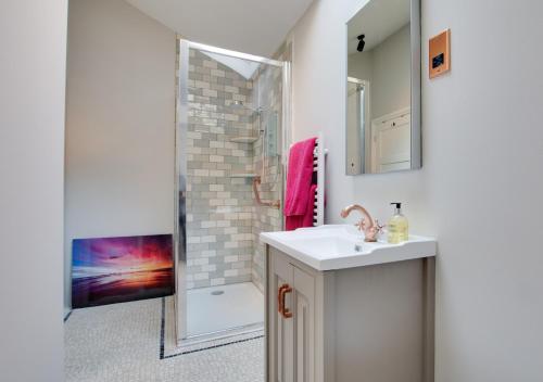 a bathroom with a sink and a shower at Melbury Abbas in Sandgate