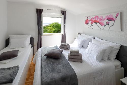 a bedroom with two beds and a window at Apartments Alen in Crikvenica
