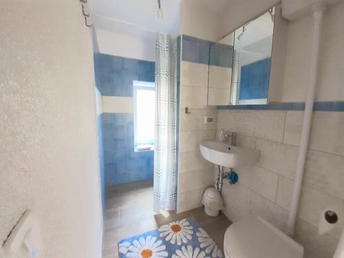 y baño con lavabo, aseo y espejo. en Apartment Vignole, en Portorož