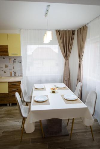 a white table and chairs in a kitchen with a window at Sweet Home in Miercurea-Ciuc