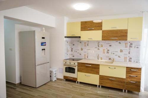 a kitchen with yellow cabinets and a white refrigerator at Sweet Home in Miercurea-Ciuc