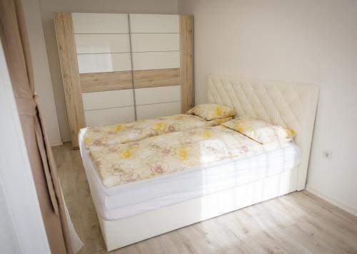 białe łóżko w białym pokoju z: w obiekcie Sweet Home w mieście Miercurea-Ciuc