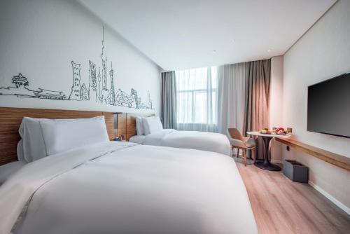 a hotel room with a large bed and a flat screen tv at Urcove by HYATT Shanghai Wujiaochang in Shanghai