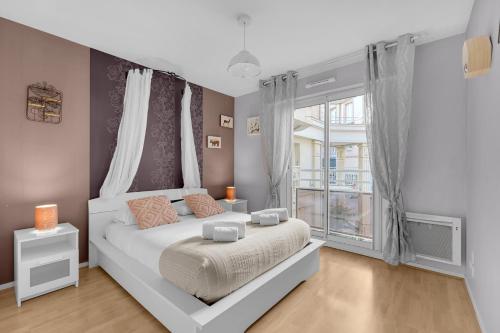 1 dormitorio con cama blanca y ventana en Prat d'Albis - Appt avec terrasse en Toulouse