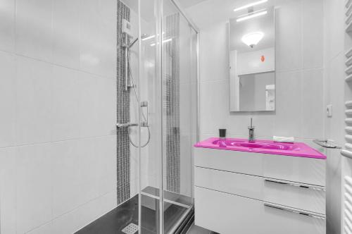 La salle de bains est pourvue d'un lavabo rose et d'une douche. dans l'établissement Prat d'Albis - Appt avec terrasse, à Toulouse