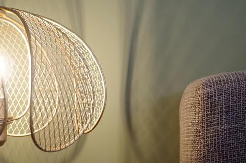 a close up of a lamp next to a couch at Das Altschwabing - Munich Boutique Hotel in Munich