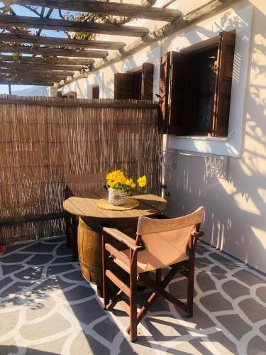 un tavolo in legno e una sedia su un patio di Niotis Studios a Calimno (Kalymnos)