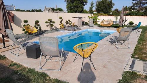 ein Swimmingpool mit Stühlen und einer darauf liegenden Katze in der Unterkunft Gite la Nouette in La Tremblade