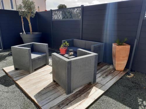 2 chaises en osier et une table sur la terrasse dans l'établissement Gite la Nouette, à La Tremblade