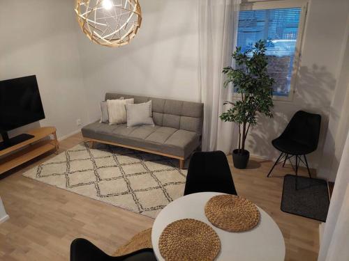 ein Wohnzimmer mit einem Sofa und einem Tisch in der Unterkunft Keskusta uusi kalustettu kaksio. in Kuopio