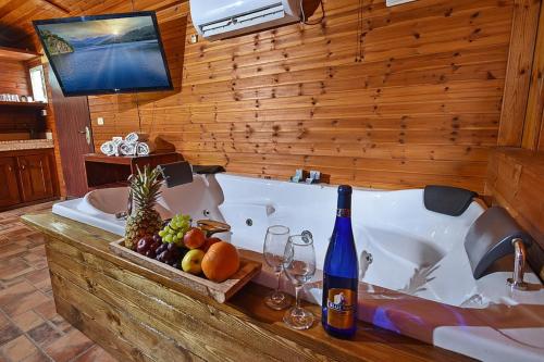 a bath tub with a bottle of wine and fruit at בקתות הר ארבל in Arbel