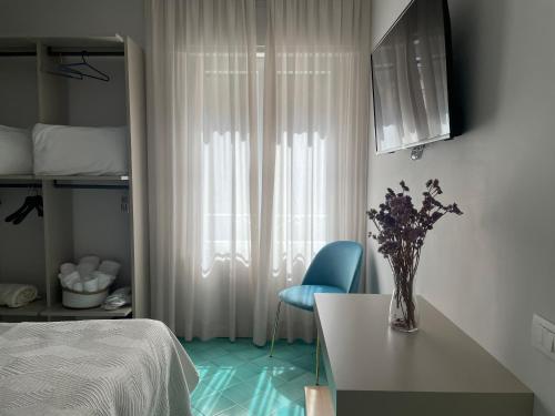a bedroom with a bed and a vase of flowers on a table at GiGa MaRe Apartments in Sorrento