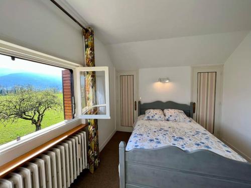 1 dormitorio con cama y ventana grande en Villa Champagne, en Champagne-en-Valromey