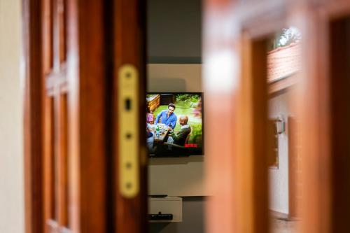 a television screen with a group of people on it at Pousada e Restaurante Terra Rossa in São José do Rio Pardo