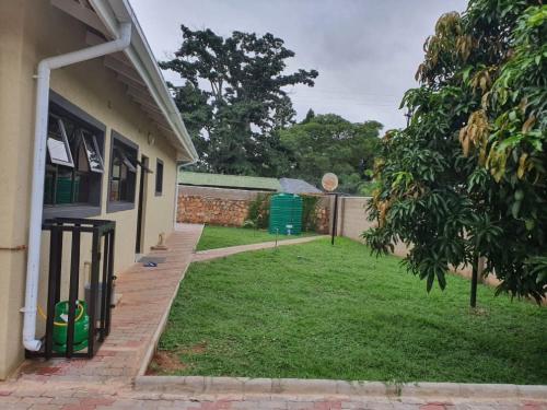 un patio junto a una casa con una valla en Posh 3 bedroomed guesthouse in Hillside with pool - 2039, en Bulawayo