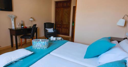 a bedroom with a bed with a table and a chair at Hostal Rural Moratín in Pastrana