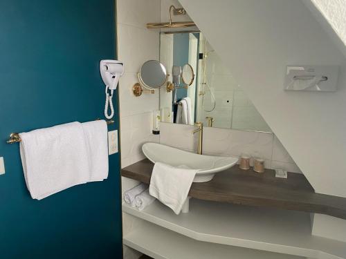 a bathroom with a sink and a mirror at Logis Hotel Restaurant A L'Etoile in Mittelhausen