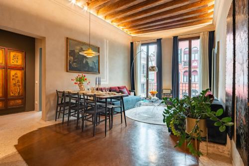 a living room with a dining room table and chairs at Cà dei Dalmati - the Blue Canal View in Venice
