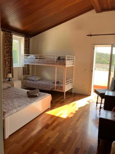 1 Schlafzimmer mit 2 Etagenbetten und Holzboden in der Unterkunft Citrus Tree House, private pool and garden. in Angeja