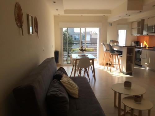 a living room and kitchen with a couch and a table at Casa Laguna Chascomus in Chascomús