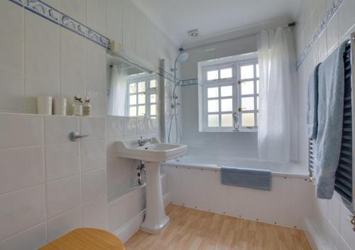 Readers Retreat في Saint Michaels: حمام أبيض مع حوض ونافذة