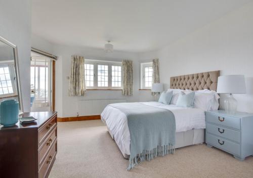 a white bedroom with a large bed and a dresser at Rockmount in Saint Margaretʼs at Cliffe