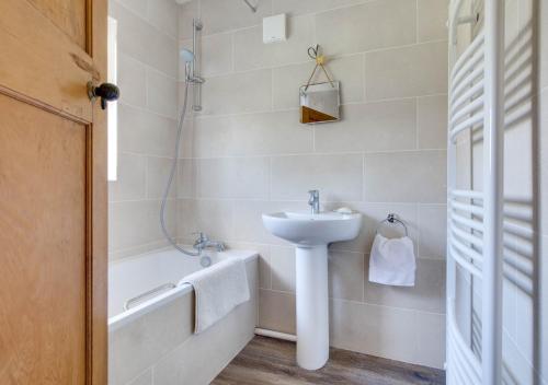 a white bathroom with a sink and a bath tub at Rockmount in Saint Margaretʼs at Cliffe