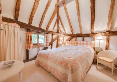 1 dormitorio con 1 cama y 1 mesa en Strawberry Hole Barn, en Northiam