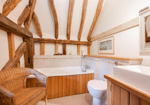 a bathroom with a toilet and a sink at Strawberry Hole Barn in Northiam