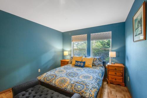 a blue bedroom with a bed and a window at Olympus View Home in Port Ludlow