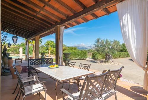 een patio met een tafel en stoelen en uitzicht bij Finca El Simpatico in Búger