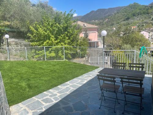 a patio with a table and chairs in a yard at Cà di Giaco lodge in Moneglia