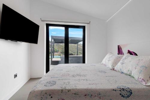 1 dormitorio con 1 cama y TV de pantalla plana en Villa Enora, en Las Palmas de Gran Canaria