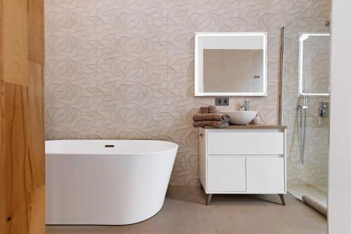 a bathroom with a white tub and a sink at Villa Enora in Las Palmas de Gran Canaria