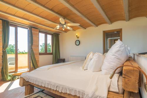 een slaapkamer met een groot bed met witte kussens bij Finca El Simpatico in Búger