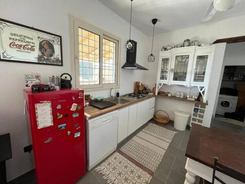cocina con nevera roja y armarios blancos en Residenza SA - tra mare e campagna, en Sannicola