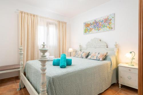 ein Schlafzimmer mit einem Bett mit einem blauen Stofftier darauf in der Unterkunft Sa Caseta -Búger- in Búger