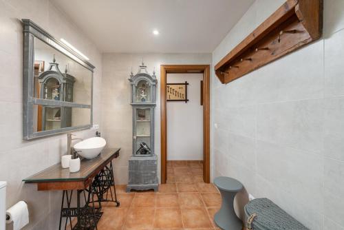 ein Badezimmer mit einem Waschbecken, einem Tisch und einem Spiegel in der Unterkunft Sa Caseta -Búger- in Búger