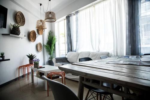 een woonkamer met een grote houten tafel en stoelen bij Let me take my bunk bed in Athene