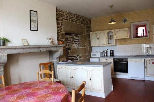 a kitchen with white cabinets and a table in a room at Maison Saint James in Saint-James