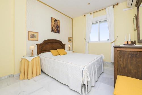 um quarto com uma cama grande e uma janela em Brisamar Golf em Chiclana de la Frontera