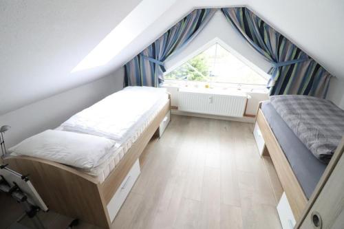 クックスハーフェンにあるNordlichtの屋根裏のベッドルーム(ベッド2台、窓付)