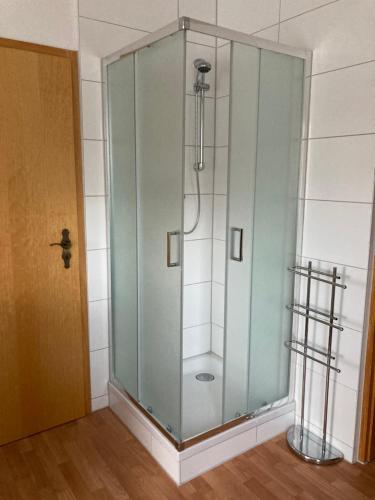 a glass shower in a room with a door at Karin's behagliche Ferienwohnung in Benshausen