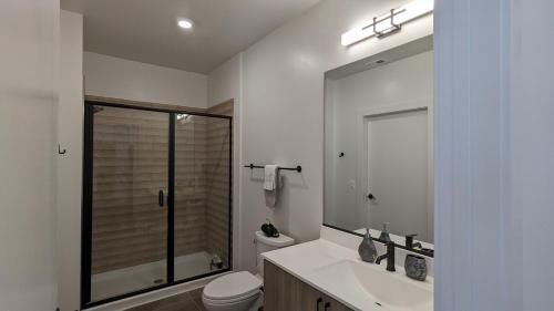 a bathroom with a toilet and a sink and a mirror at Downtown One Loudoun in Ashburn